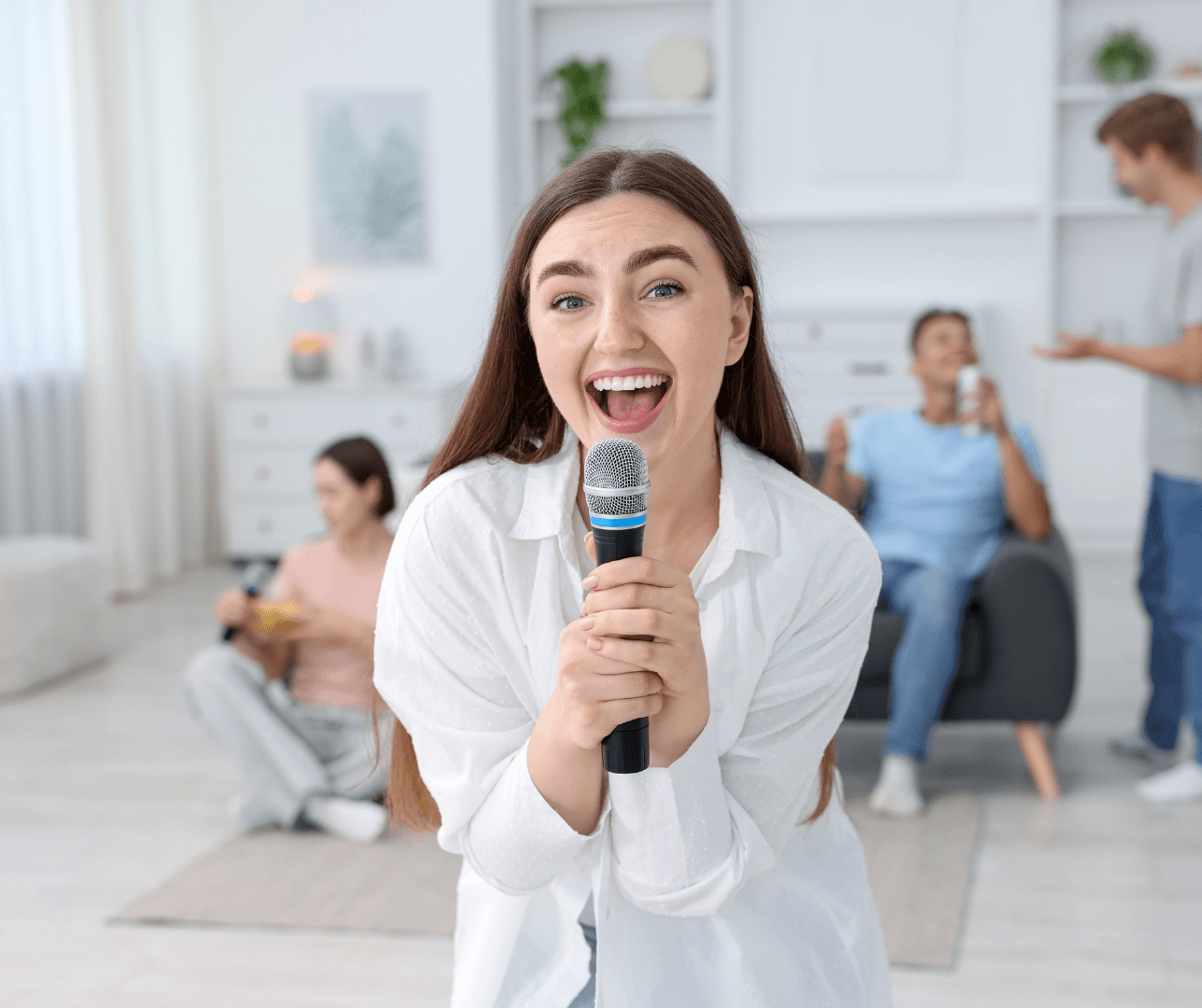 A singer holding a microphone in a bright living room.