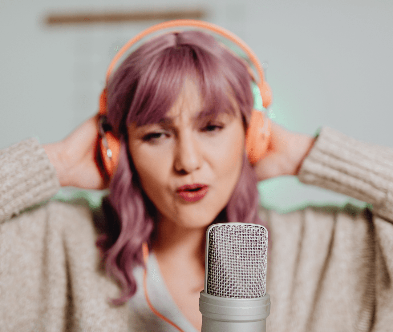 A singer wearing headphones and performing into a microphone.